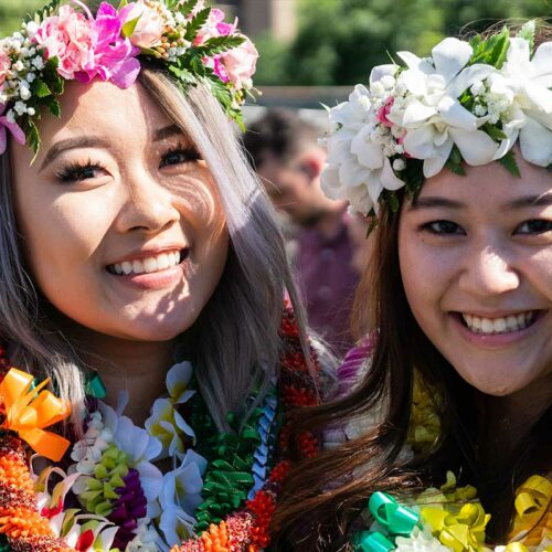 two graduates wearing head lei