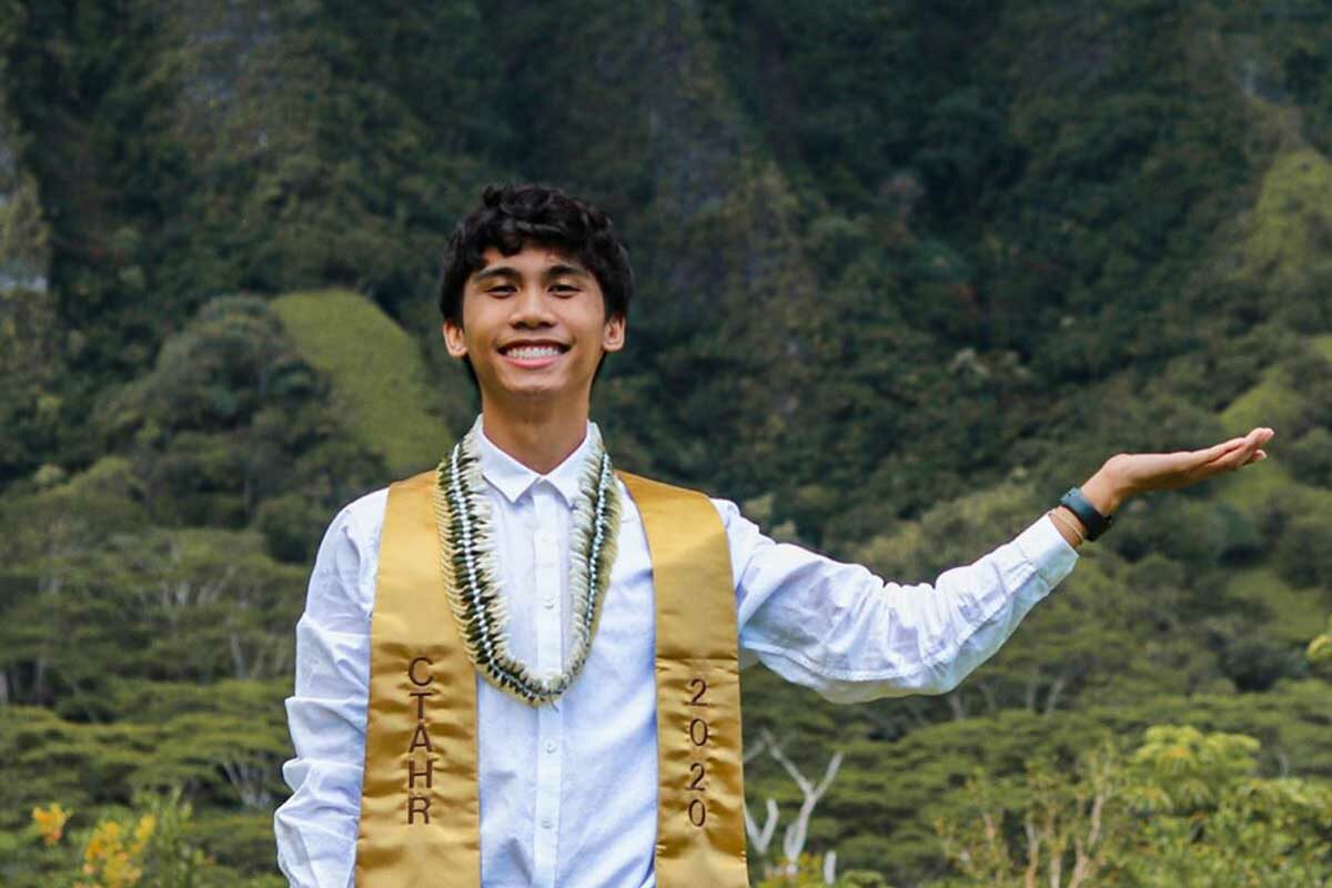 portrait of graduate wearing sash with mountains in background