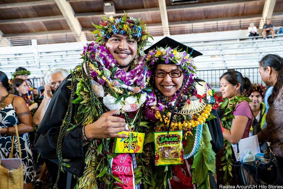graduates adorned in numerous lei